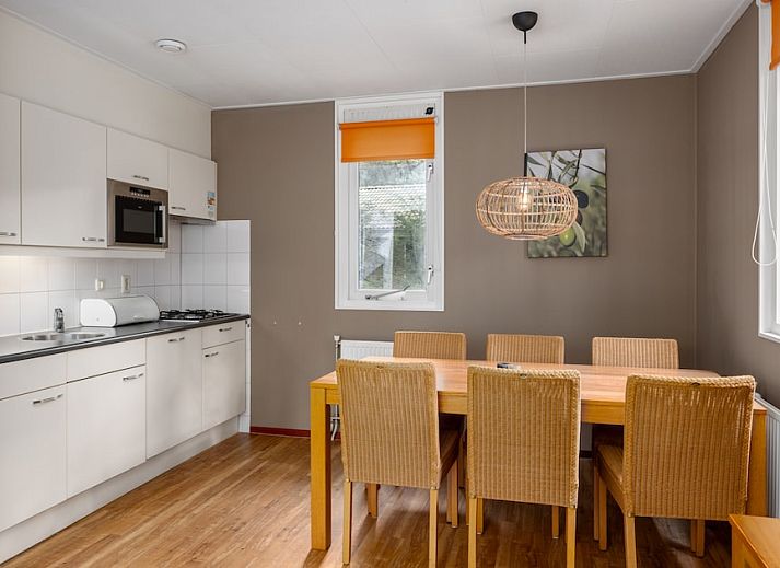 Gemuetliches Wohnzimmer des Bungalows L6A in Borger, Nord-Drenthe mit bequemer Sitzecke und Blick auf die umliegende Landschaft.