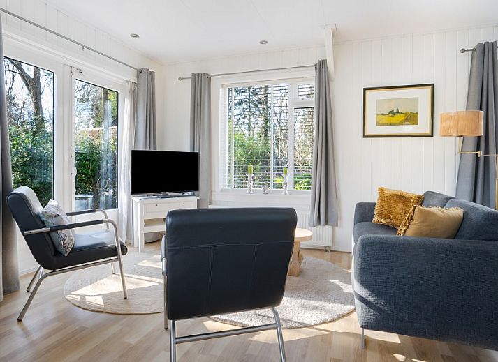 Gemuetliches Wohnzimmer des Ferienhauses Vogelzang in Borger, Drenthe, mit Blick auf den Garten und bequemen Sitzgelegenheiten.