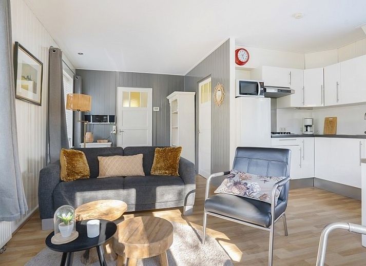 Gemuetliches Wohnzimmer des Ferienhauses Vogelzang in Borger, Drenthe, mit Blick auf den Garten und bequemen Sitzgelegenheiten.