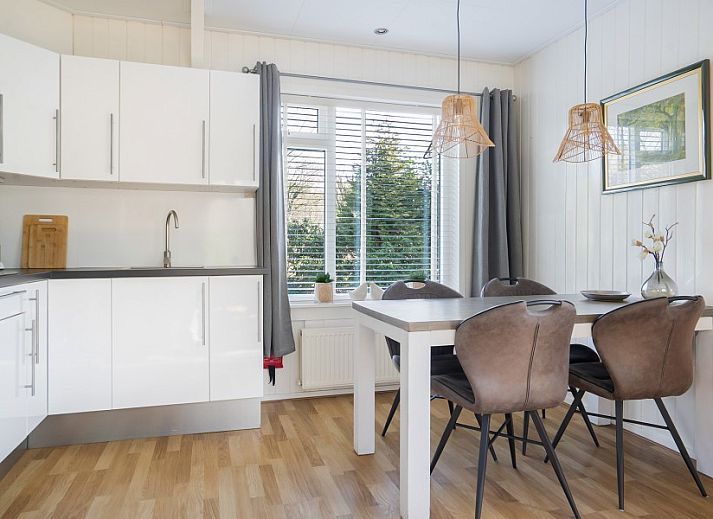 Gemuetliches Wohnzimmer des Ferienhauses Vogelzang in Borger, Drenthe, mit Blick auf den Garten und bequemen Sitzgelegenheiten.