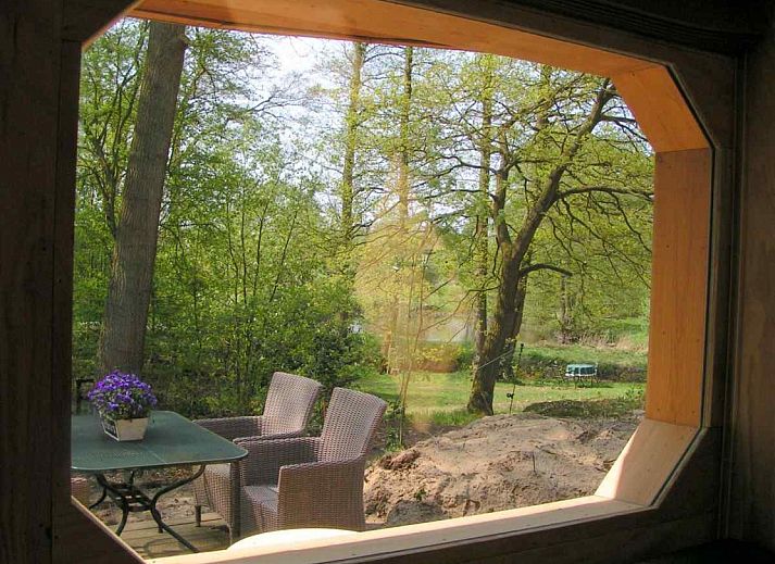 Gemuetliches Wohnzimmer des DG575 Ferienhauses in Schipborg, Drenthe mit Blick auf den Wald.