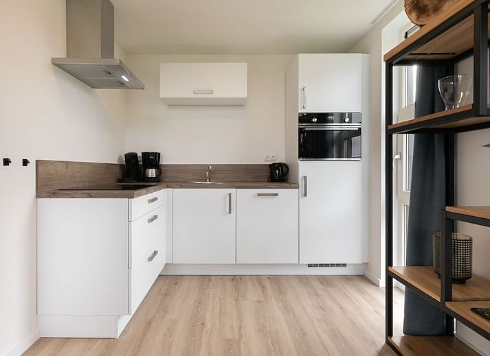 Modern living room in Drentsche E bungalow, Tynaarlo, with large windows and views of green surroundings in North Drenthe.
