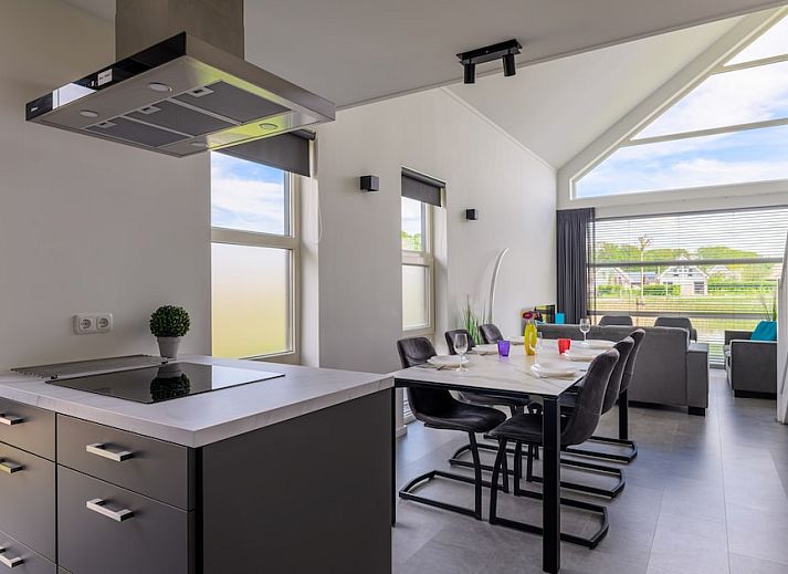 Bright living room of Drentsche E Plus bungalow in Tynaarlo, North Drenthe with modern furnishings and views of green surroundings.
