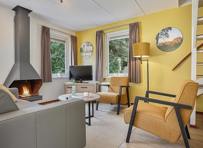Moderne woonkamer van Het Land van Bartje 6-persoons landhuis in Ees, met comfortabele banken en open keuken.