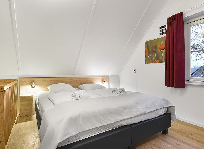 Ruime woonkamer met openslaande deuren in Het Land van Bartje 10-persoons boerderij, Ees.