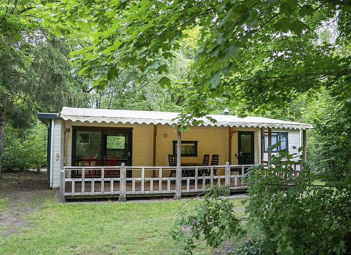 Eettafel in Het Land van Bartje 4-persoons peuterstacaravan in Ees, Drenthe met kleurrijk servies.