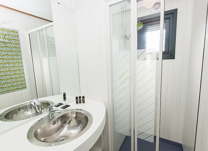 Veranda van Het Land van Bartje 4-persoons peuterstacaravan in Ees, omgeven door groen.