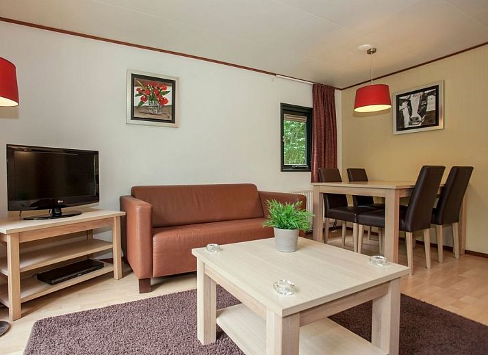 Cozy living room in Het Land van Bartje 4-person mobile home 4BCV in Ees, Drenthe, with comfortable seating area and dining table.