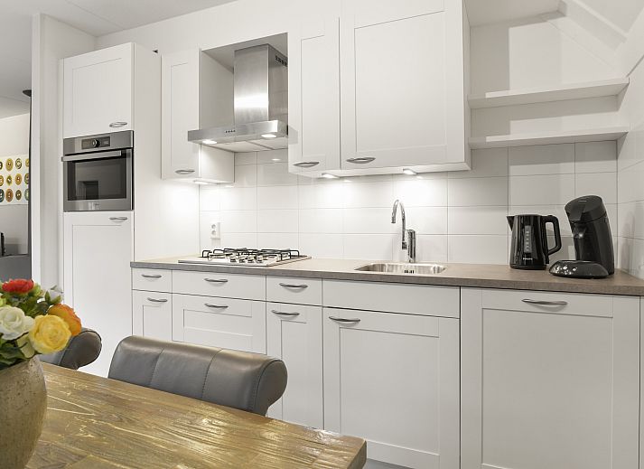 Geraeumige Terrasse mit Sonnenschirm im 6-Personen-Bauernhaus Het Land van Bartje in Ees, Drenthe. Ideal fuer Mahlzeiten im Freien.