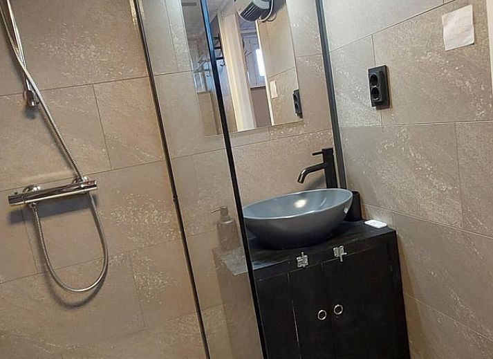 Moderne woonkamer met flatscreen TV in Huisje in Lieveren, vakantiehuis in Noord Drenthe.