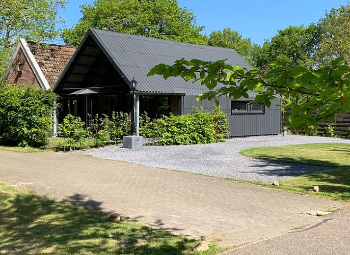 Veranda von Cottage in Vries, Ferienhaus in Drenthe mit Picknicktisch und Sonnenschirm.