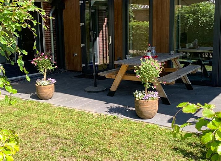 Veranda von Cottage in Vries, Ferienhaus in Drenthe mit Picknicktisch und Sonnenschirm.