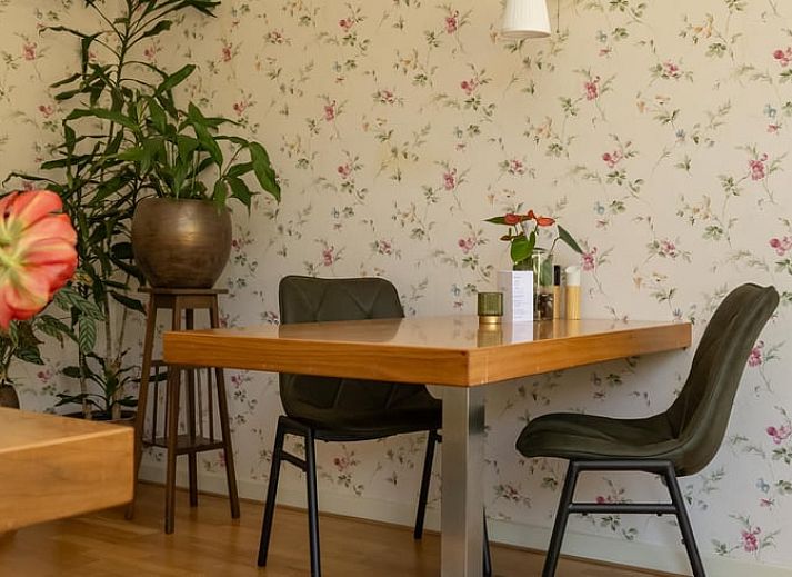 Cozy bedroom in a cottage in Veenhuizen, North Drenthe, with colorful bedding and a view of the green surroundings.