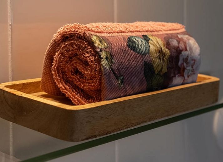 Cozy bedroom in a cottage in Veenhuizen, North Drenthe, with colorful bedding and a view of the green surroundings.