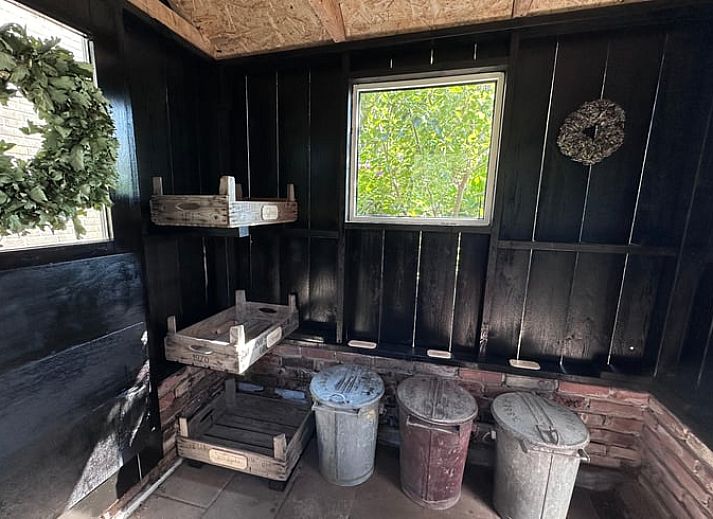 Unieke muurdecoraties in Vakantiehuisje in Ekehaar, Drenthe, met een moderne klok en kunstwerken.