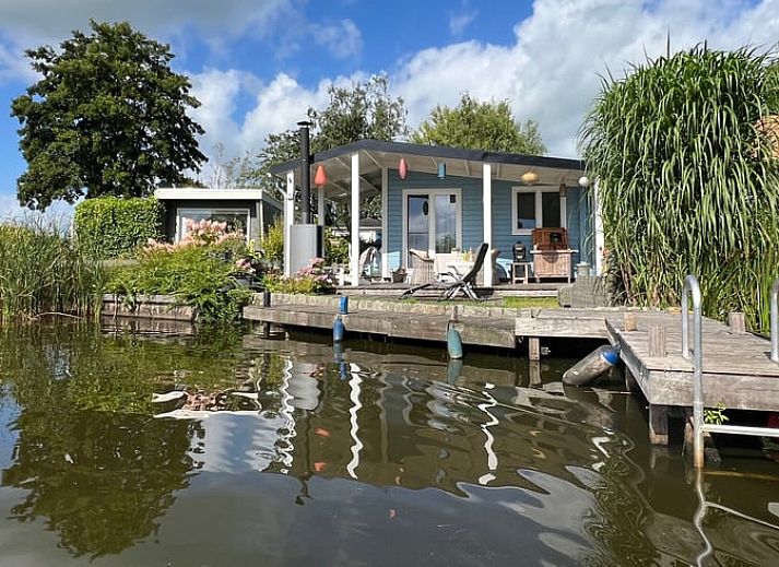 Geniessen Sie die ruhige Veranda des Huisje in Matsloot, einem Ferienhaus am Wasser in Nord-Drenthe, mit schoenem Seeblick.