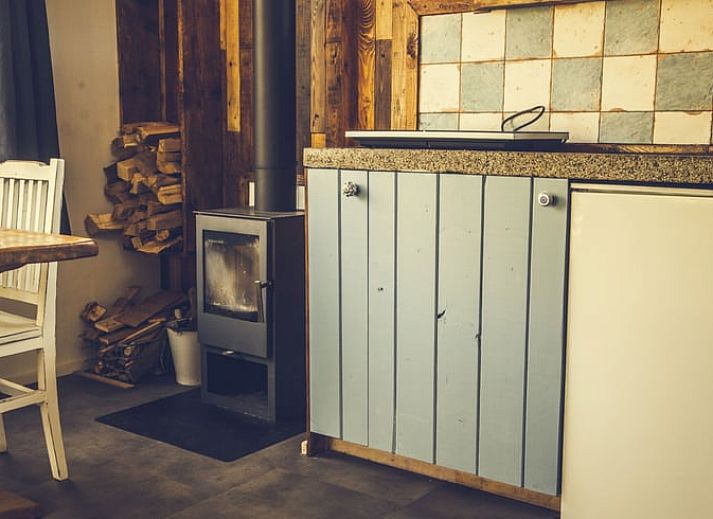 Gezellig terras bij Vakantiehuis in Drouwenerveen, Noord Drenthe, met vuurplaats en houten stoelen.