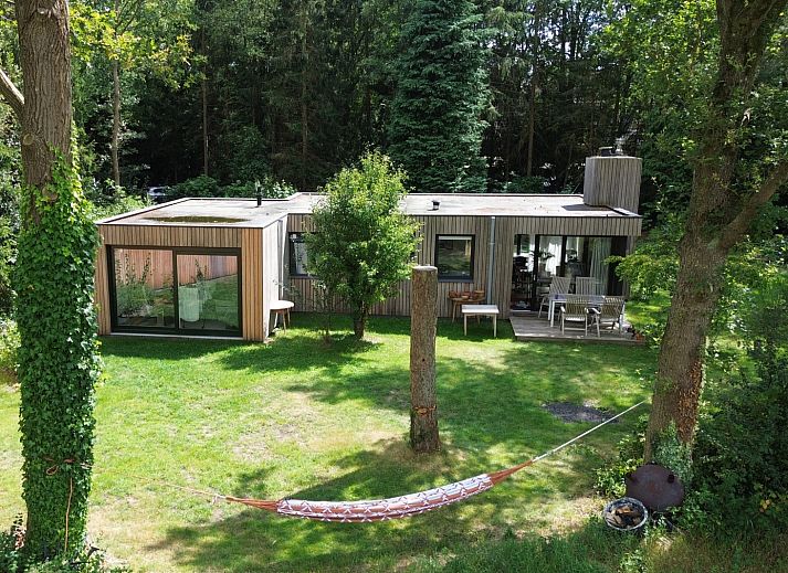 Ferienhaus DG357 in Meppen, Drenthe mit gruenem Garten und Haengematte zur Entspannung.