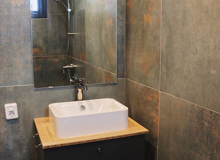 Natuerliche Umgebung des Ferienhauses DG357 in Meppen, Drenthe mit einem Grashuepfer auf einem Stuhl.