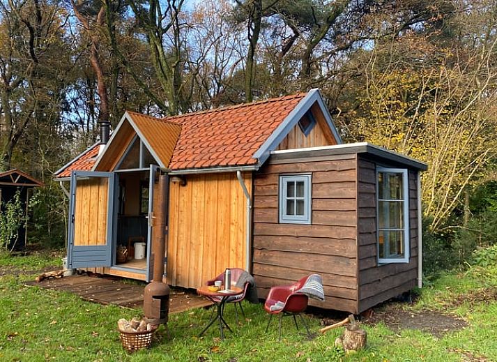 Gemuetlicher Innenbereich des Ferienhauses in Meppen mit Kaminofen und bunten Stuehlen, ideal zum Wohlfuehlen.