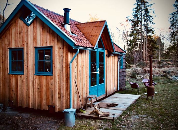 Gemuetlicher Innenbereich des Ferienhauses in Meppen mit Kaminofen und bunten Stuehlen, ideal zum Wohlfuehlen.