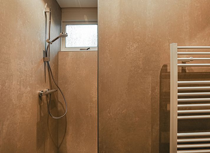 Innenansicht des Aelderholt 6-Personen-Bungalows 6C in Aalden, Drenthe mit Esszimmer und Kamin.