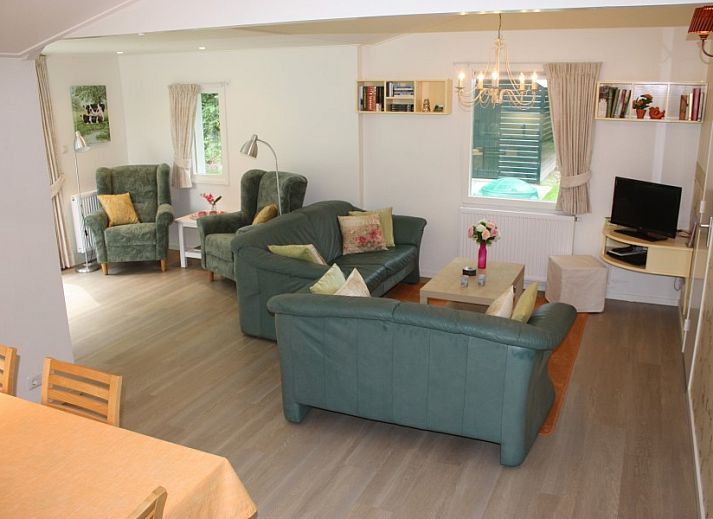 Cozy living room of clean holiday bungalow in Exloo, Drenthe overlooking the garden.