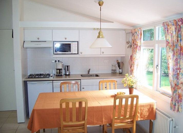 Cozy living room of clean holiday bungalow in Exloo, Drenthe overlooking the garden.