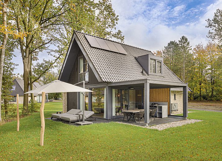 Das Ferienhaus PUUR Exloo in Exloo, Drenthe, bietet eine idyllische Aussicht mit Terrasse und gruener Umgebung.