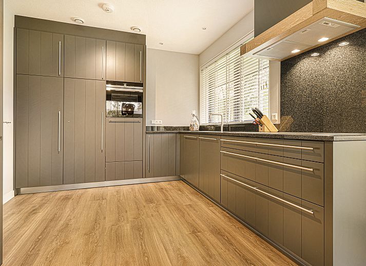 Gemuetlicher Innenbereich des Ferienhauses PUUR Exloo in Exloo, Drenthe, mit moderner Kueche und Essbereich.