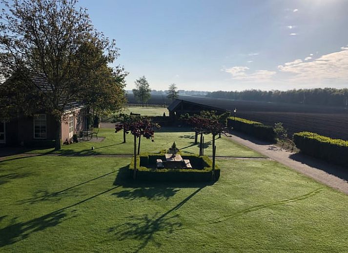 Vacation home in Exloo, Drenthe, with shady porch and manicured garden.