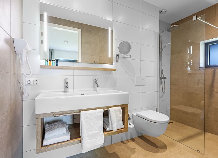 Stijlvolle woonkamer van PUUR Exloo vakantiehuis in Drenthe met groene accenten.