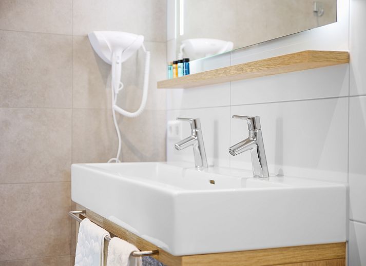 Stijlvolle woonkamer van PUUR Exloo vakantiehuis in Drenthe met groene accenten.