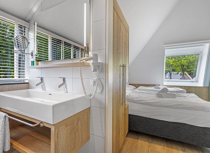 Stijlvolle woonkamer van PUUR Exloo vakantiehuis in Drenthe met groene accenten.