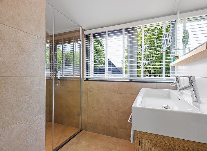 Stijlvolle woonkamer van PUUR Exloo vakantiehuis in Drenthe met groene accenten.