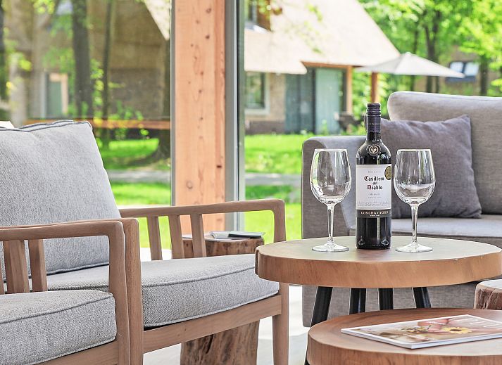 Wijn en glazen op salontafel in PUUR Exloo vakantiehuis in Zuidoost Drenthe.