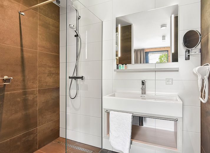 Lichte woonkamer met grote ramen in PUUR Exloo vakantiehuis in Zuidoost Drenthe.