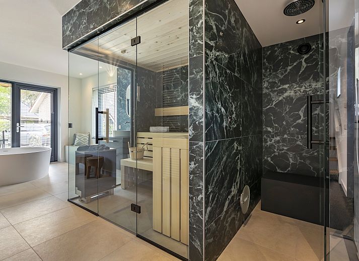 Gezellige woonkamer in PUUR Exloo vakantiehuis in Exloo met moderne meubels en veel lichtinval.