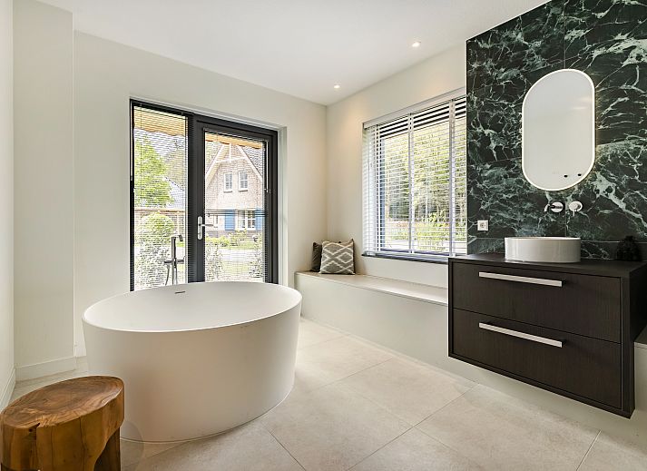 Gezellige woonkamer in PUUR Exloo vakantiehuis in Exloo met moderne meubels en veel lichtinval.