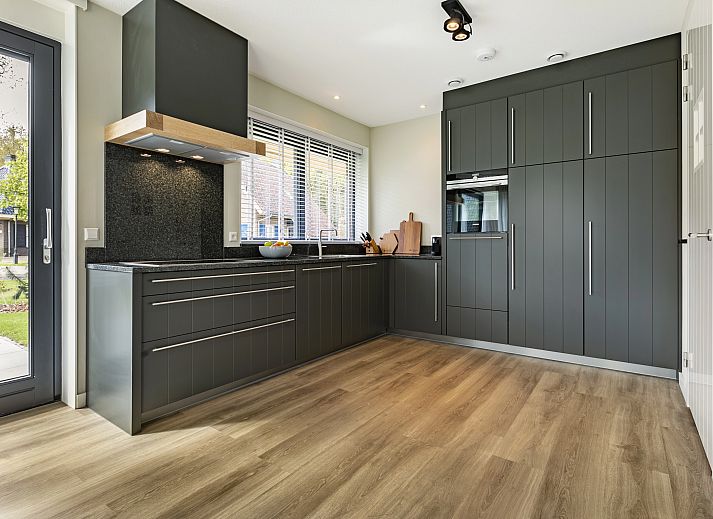 Gezellige woonkamer in PUUR Exloo vakantiehuis in Exloo met moderne meubels en veel lichtinval.