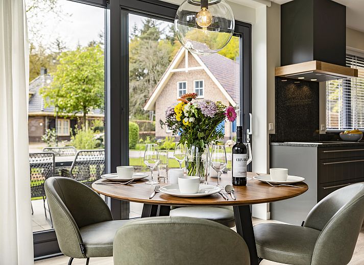 Eethoek in PUUR Exloo vakantiehuis in Zuidoost Drenthe met bloemen en moderne inrichting.