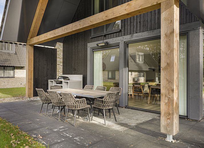 Gemuetliches Wohnzimmer des PUUR Exloo Ferienhauses mit Blick auf die Natur in Exloo, Drenthe.