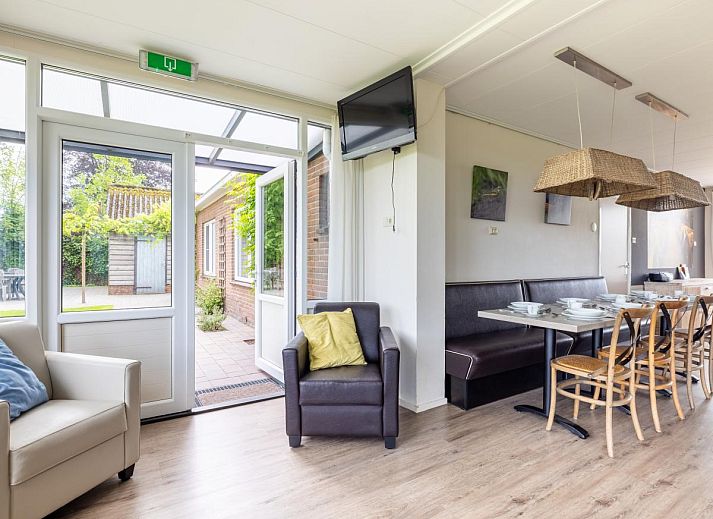 Geniessen Sie die Ruhe und den Frieden im Ferienhaus Zonnehoek in Exloo, Drenthe. Geraeumige Terrasse mit Gartenmoebeln, umgeben von gruener Natur.