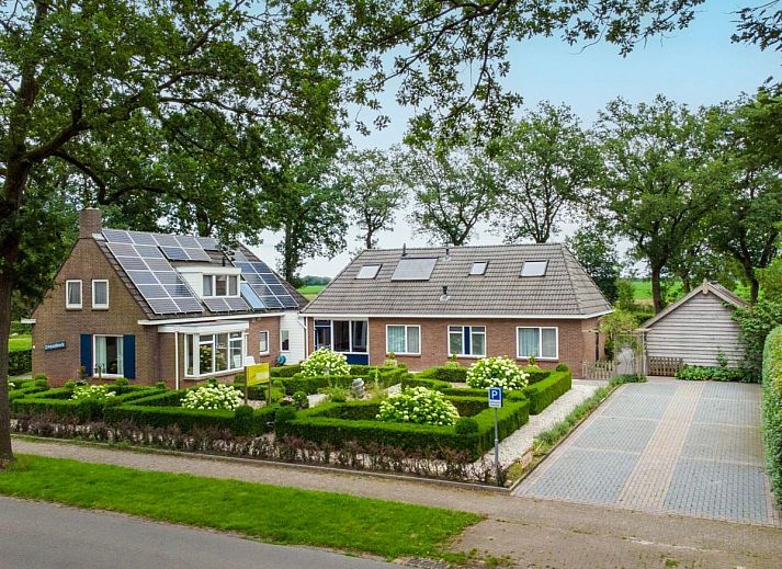 Gemuetliche Essecke im Ferienhaus Zonnehoek, Exloo, mit Holzstuehlen und Korblampen, ideal fuer einen Familienurlaub im Suedosten von Drenthe.