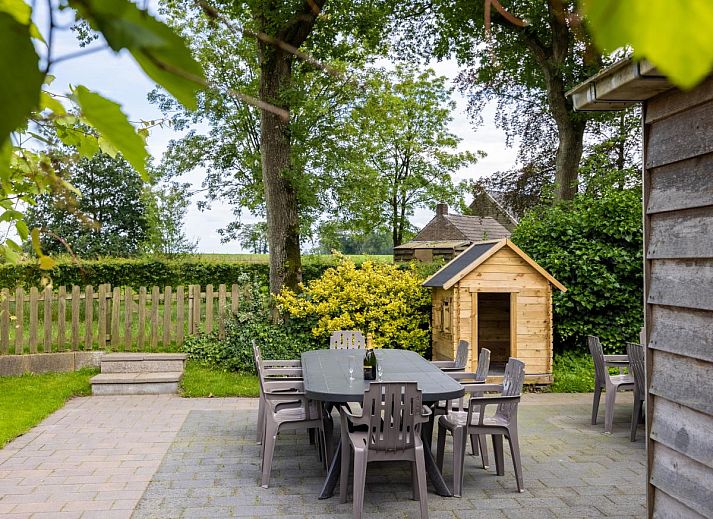 Gemuetliche Essecke im Ferienhaus Zonnehoek, Exloo, mit Holzstuehlen und Korblampen, ideal fuer einen Familienurlaub im Suedosten von Drenthe.