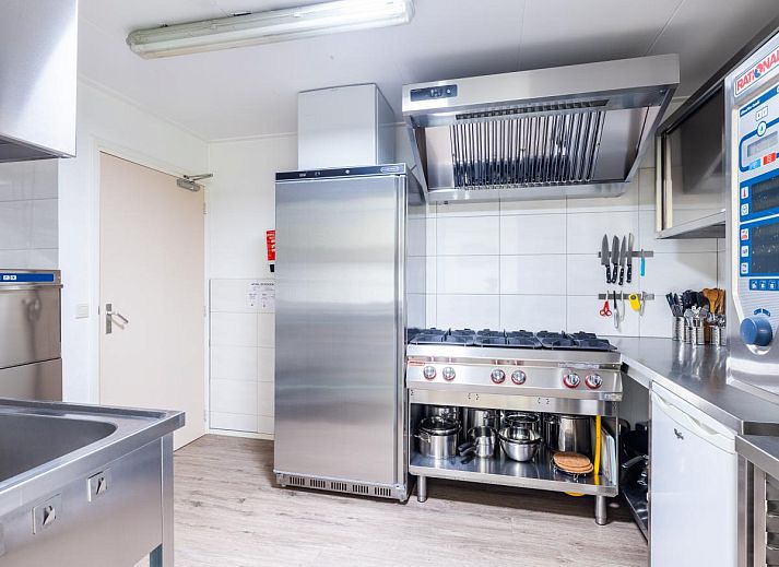 Gemuetliche Essecke im Ferienhaus Zonnehoek, Exloo, mit Holzstuehlen und Korblampen, ideal fuer einen Familienurlaub im Suedosten von Drenthe.