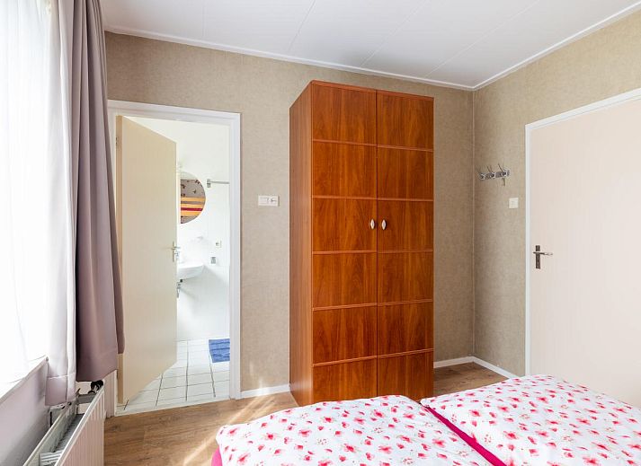 Gemuetliches Wohnzimmer im Ferienhaus Zonnehoek, Exloo, Drenthe mit Blick auf die gruene Natur durch grosse Fenster.