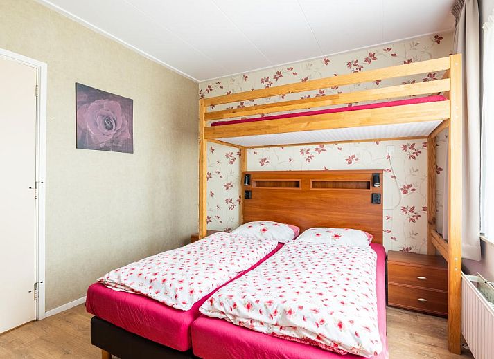 Gemuetliches Wohnzimmer im Ferienhaus Zonnehoek, Exloo, Drenthe mit Blick auf die gruene Natur durch grosse Fenster.