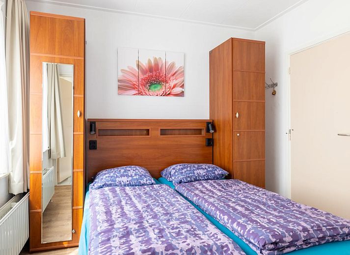 Gemuetliches Wohnzimmer des Ferienhauses Zonnehoek in Exloo, Drenthe, mit grosser Sitzecke und Blick auf die gruene Umgebung.