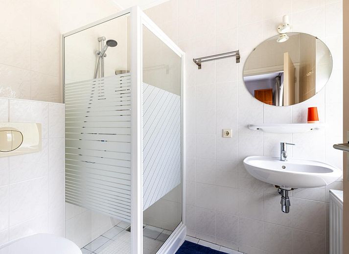 Gemuetliches Wohnzimmer des Ferienhauses Zonnehoek in Exloo, Drenthe, mit grosser Sitzecke und Blick auf die gruene Umgebung.